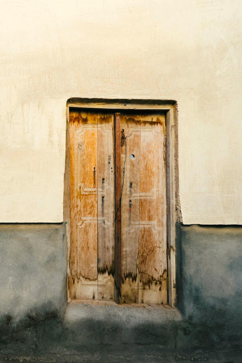 Weathered wooden door in a plastered wall