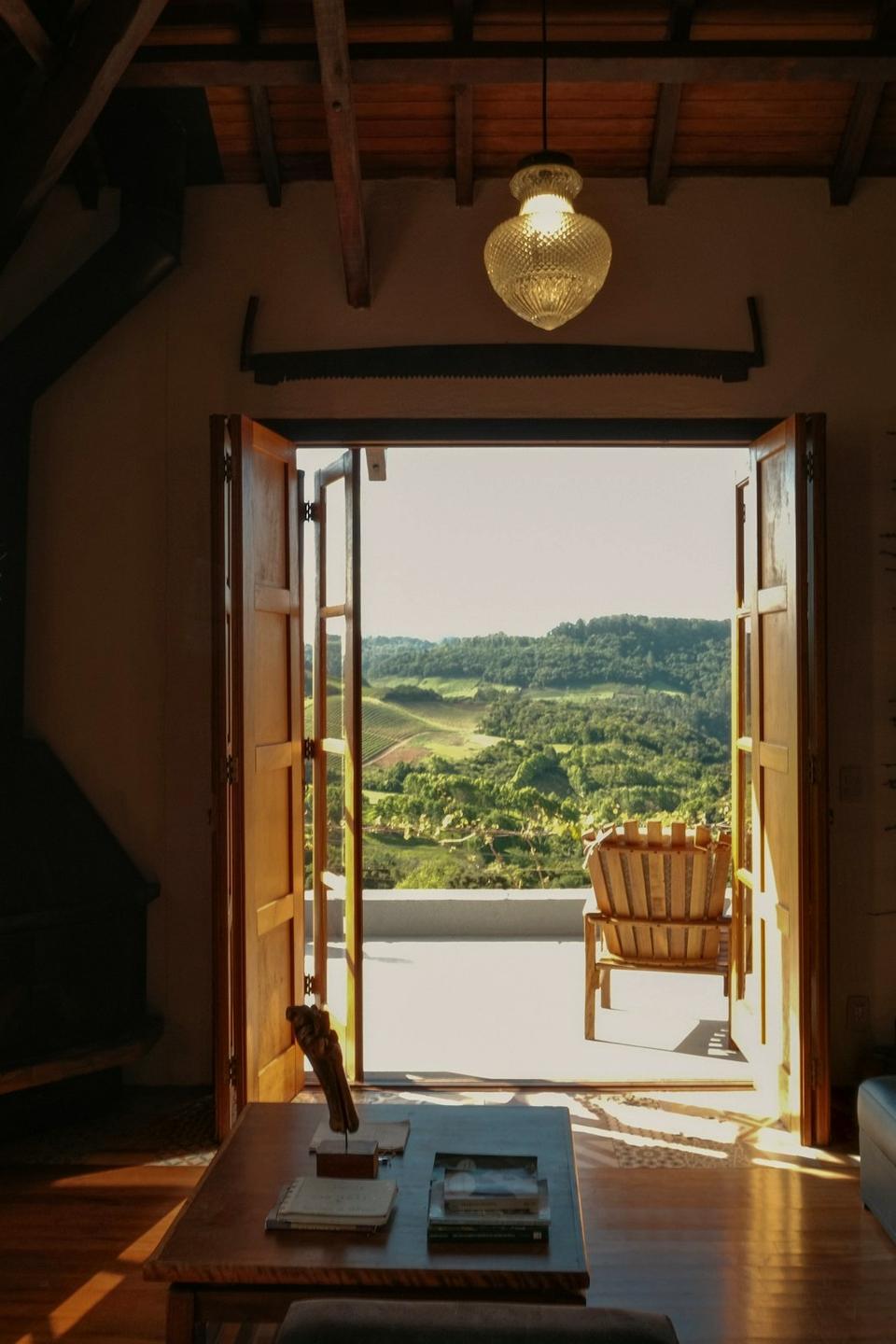 Open doors under wooden beams looking onto green Portuguese hills