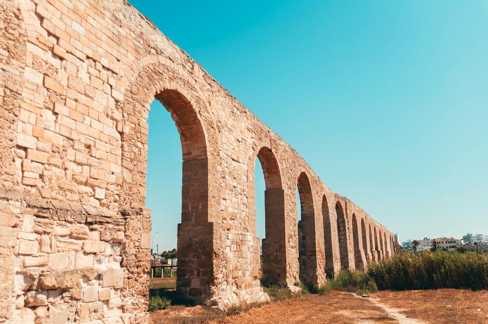 The sandstone arches of the historic Kamares aqueduct in Larnaca under a blue sky