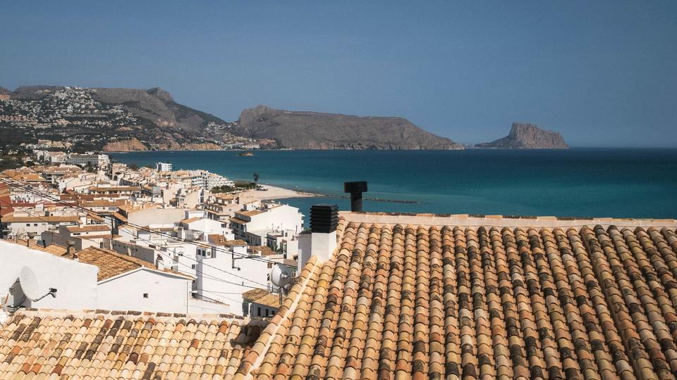 Terracotta rooftops and white houses of Altea overlooking the blue bay and the Sierra Helada headland